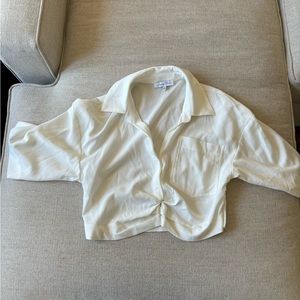 White cropped button up blouse with front pockets and zip on bottom left